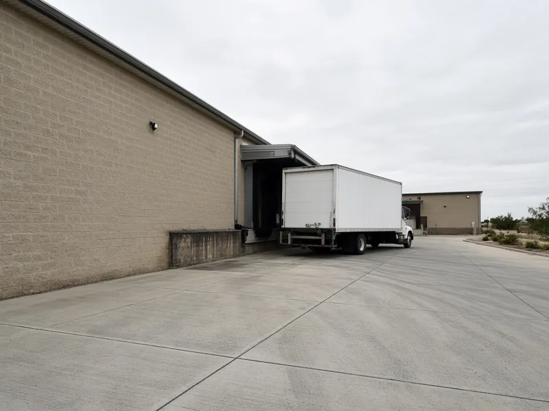 Heavy-duty concrete truck lane at a loading dock behind a commercial building, Abilene, TX